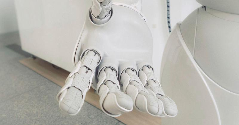 A robotic hand of a white robot reaching out
