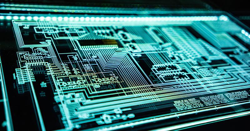 Circuit board glowing under a blacklight